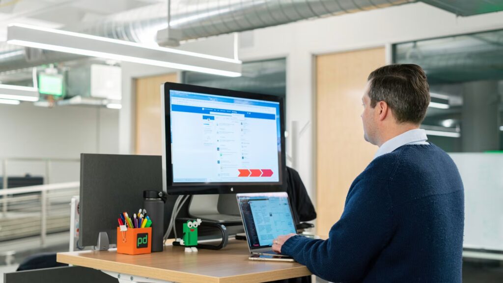 A man managing a LinkedIn profile on a computer